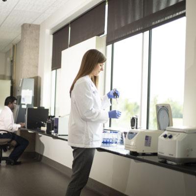 Medical professional in white lab coat working in a lab.