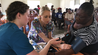 A female pharmacy student helps an elderly woman