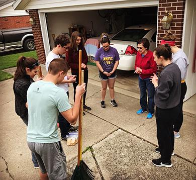 Students praying women after raking