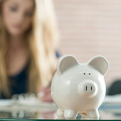 A white piggy bank sits on a table